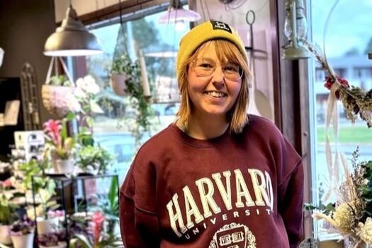 Halvkroppsbild inomhus i av entreprenören Jasmine Bendel. Fotot är taget inomhus i en blomsterhandel